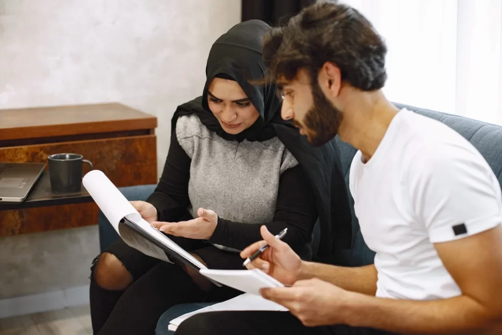 beautiful young couple writing notebook sitting couck home arab girl wearing black hidjab 1536x1024.jpg