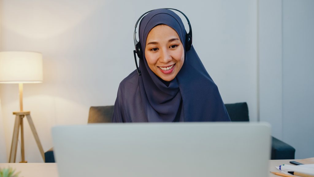 muslim lady wear headphone watch webinar listen online course communicate by conference video call night home office